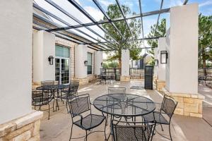 Best Western Lubbock West Inn & Suites في لوبوك: فناء به طاولات وكراسي وسقف زجاجي