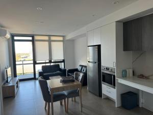 una cucina e un soggiorno con tavolo e sedie di Blacktown Cozy Retreat a Blacktown