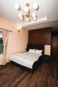 1 dormitorio con 1 cama y ventilador de techo en RR Forest View, en Ooty