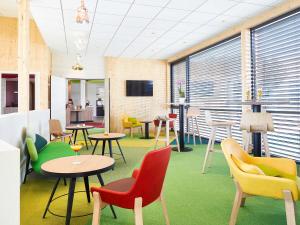 Una televisión o centro de entretenimiento en Ibis Styles Colmar Nord