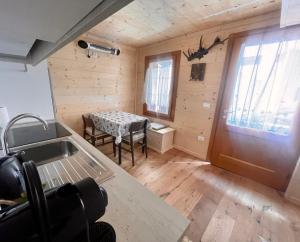 um pequeno quarto com uma mesa e uma janela em Nido Ampezzano em Borca di Cadore