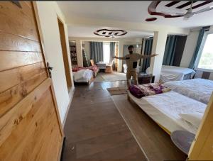 a man standing in a bedroom with two beds at Mount View Hotel Skardu in Skardu