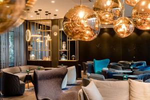 Motel One Nürnberg-Plärrer في نورنبرغ: مطعم به طاولات وكراسي وثريات