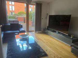 曼彻斯特Luxury Modern Town House, Manchester City Centre, Free Secured Parking的客厅配有大屏幕平面电视