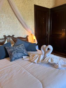 a bed with two swans made out of towels at Juliette Posada Boutique Ex Posada La Villa in Villa Carlos Paz