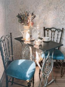 a black table with two chairs and a table with a bowl of flowers at Juliette Posada Boutique Ex Posada La Villa in Villa Carlos Paz