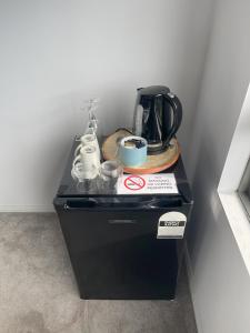 een zwarte bar met een koffiezetapparaat en kopjes erop bij Bridgewater Apartments in Brisbane