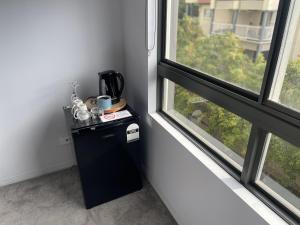 een kleine zwarte koelkast in een kamer met 2 ramen bij Bridgewater Apartments in Brisbane