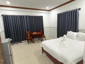 um quarto com uma cama, uma mesa e cadeiras em I Hostel Muine - A Little White Homestay By The Sea em Mui Ne