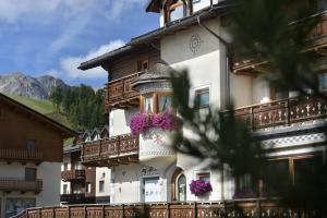 um edifício com caixas de flores ao lado em Hotel Crosal em Livigno