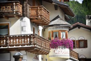 um edifício com varandas de madeira e flores em Hotel Crosal em Livigno