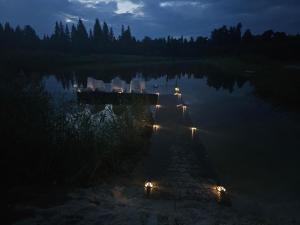 een dok met stoelen en lichten in het water 's nachts bij Bille in Bille