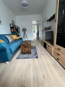 a living room with a blue couch and a tv at CityLife InApartment Salzburg in Salzburg