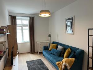 a living room with a blue couch and a window at CityLife InApartment Salzburg in Salzburg