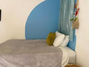 een bed in een kamer met een blauwe muur bij Nómade in San Juan La Laguna