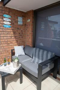 ein Sofa und einen Tisch auf einer Terrasse in der Unterkunft Joy's Hideaway in Terrigal