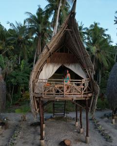 two people are sitting in a thatch hut at Isla - The Island Experience in El Nido