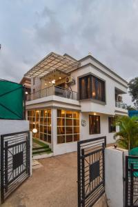 uma grande casa branca com uma varanda em EMPYREAN STAY ll 4BHK II KOHINOOR VILLA ll PRIVATE POOL II AC II LUXURY ll TUNGARLI em Lonavala