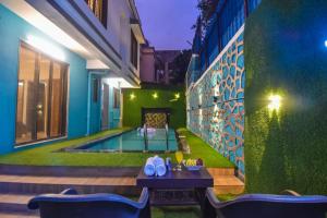 um pátio com uma mesa e cadeiras ao lado de uma piscina em EMPYREAN STAY ll 4BHK II KOHINOOR VILLA ll PRIVATE POOL II AC II LUXURY ll TUNGARLI em Lonavala