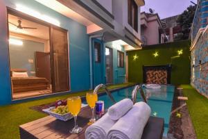 uma piscina com mesa e copos de sumo de laranja em EMPYREAN STAY ll 4BHK II KOHINOOR VILLA ll PRIVATE POOL II AC II LUXURY ll TUNGARLI em Lonavala