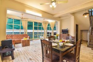 uma sala de estar com uma mesa de jantar e um sofá em EMPYREAN STAY ll 4BHK II KOHINOOR VILLA ll PRIVATE POOL II AC II LUXURY ll TUNGARLI em Lonavala