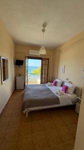 a bedroom with a large bed with a view of the ocean at romanza rooms in Poúlithra