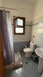 a bathroom with a toilet and a sink at romanza rooms in Poúlithra