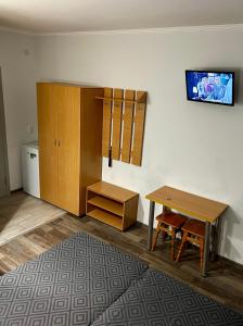 Cette chambre comprend un bureau, une table et une armoire. dans l'établissement Ассоль, à Kobleve