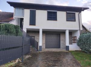 una casa blanca con una puerta y un garaje en B&D apartment, en Maribor