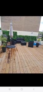 - une terrasse avec des chaises et un parasol sur le parquet dans l'établissement Appart 150 m2 luxembourg à proximité, à Thionville