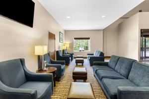 uma sala de espera com sofás e cadeiras e uma televisão em Comfort Suites Grayslake near Libertyville North em Grayslake