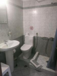 a bathroom with a white toilet and a sink at romanza rooms in Poúlithra