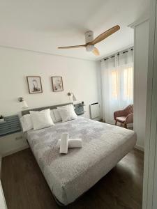 een slaapkamer met een groot bed en een plafondventilator bij En el corazón de Santander in Santander