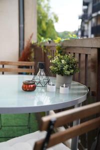 une table avec une lampe et des plantes en pot sur un balcon dans l'établissement L'Atelier de rêves, à Metz