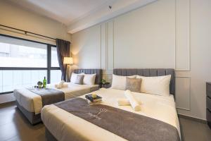 una camera d'albergo con due letti e una finestra di Mossaz Suites by Mykey Global a Petaling Jaya