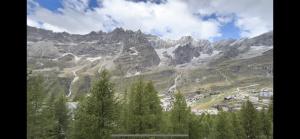 vista su una catena montuosa con alberi e case di Cervinia Snow Dream Apartments a Breuil-Cervinia