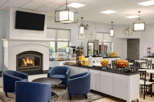 una cucina con camino e sedie blu di Days Inn by Wyndham Hershey a Hershey