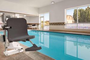 una piscina con una sedia di fronte alla piscina di Days Inn by Wyndham Hershey a Hershey