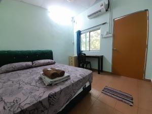 - une chambre dotée d'un lit avec un ours en peluche sur un plateau dans l'établissement Tony’s Guesthouse at Teluk Bahang, à Batu Ferringhi