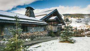 een blokhut in de sneeuw met een schoorsteen bij Zannier Le Chalet in Megève