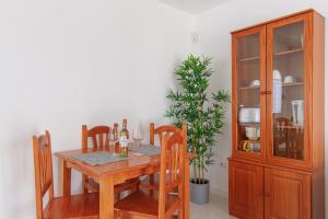 uma sala de jantar com mesa e cadeiras e um armário em Las Casitas de Corralejo em Corralejo