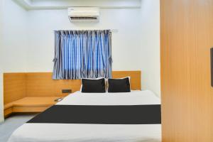 een slaapkamer met een bed met 2 kussens en een raam bij Super OYO Hotel O S Boss in Jogeshwāri