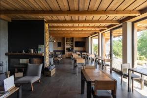 een restaurant met houten plafonds en tafels en stoelen bij Montem in Matraszentistvan