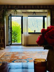 Habitación con ventana grande y mesa con flores en Iepurasul Sinaia, en Sinaia