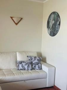 a white couch in a room with a clock on the wall at T1 Vista Marina de Vilamoura in Vilamoura