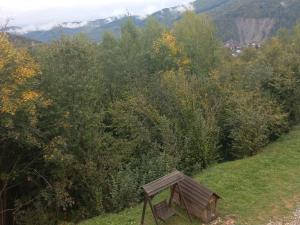 una panchina di legno seduta sul fianco di una collina di Villa Gold a Jaremče