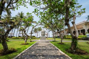 una estatua frente a un edificio con árboles en Nirwana Beach & Resort, en Candidasa