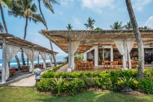 un restaurante en la playa con palmeras en Nirwana Beach & Resort, en Candidasa