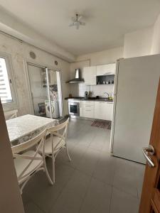 una cucina con tavolo e frigorifero di Luxueux appt jardin de Carthage a La Goulette (La Goletta)