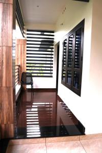 a hallway with wooden floors and windows with blinds at ECOSTAY inn in Sultan Bathery